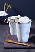 Cups of cocoa with marshmallows on bamboo sticks