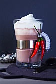 Kakaoglas mit Chilischoten und Milchhaube
