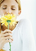 Woman smelling flower with eyes closed