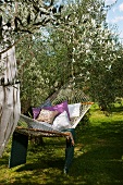 Relaxing in hammock with cushions in Mediterranean garden