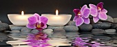 Entspannung im Spa - Teelichter und Orchideenblüten im Wasser gespiegelt