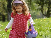A girl looking for Easter eggs in a meadow