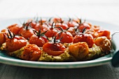 Pizza topped with cherry tomatoes, pesto and ricotta