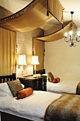 Bedroom in warm earthy shades - golden brown silk canopies above twin beds made of dark, African wood