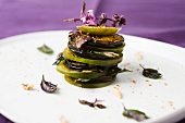 A tomato and aubergine tower with basil and sesame seeds