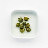 Capers in brine on a white dish