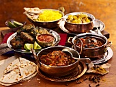 Various Indian dishes with rice and naan bread