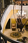 Antiker Kerzenleuchter und Blick von oben auf ein Fliesenornament in die Eingangshalle einer herrschaftlichen Villa