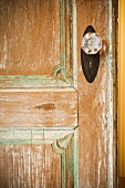 Teilweise restaurierte Holztür mit Profilen und Türdrehknopf