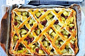 A lattice potato and ham pie on a baking tray