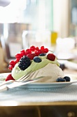 A meringue topped with vanilla cream and berries