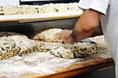Bread dough with olives being kneaded
