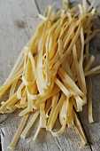 Homemade tagliatelle on a wooden surface