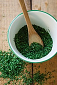 Dried parsley in a bowl with a wooden spoon