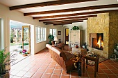 Living room with stone fireplace and double doors open to backyard