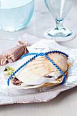 Small present: scallop shells filled with sweets and tied with cord holding name card