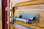 Old wooden door with brass door handle and key in lock