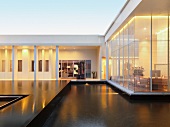 Zeitgenössische Architektur mit Pool im Innenhof und Blick in beleuchtete Räume
