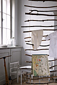 Hanging DIY ladder made from branches with children's clothes and picture book