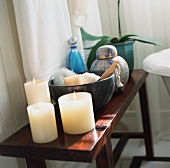 Kerzen neben Schale und Keramikbehälter auf Beistelltisch aus dunklem Holz