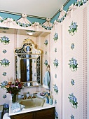 Corner of nostalgic bathroom with floral patterns, wooden washstand, Venetian-style mirror and cosmetics