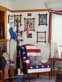 American room with whimsical Uncle Sam figure, stars and stripes armchair and collection of pictures on wall