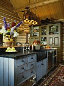 Rustic, cosy kitchen with rug and ceiling-height kitchen dresser