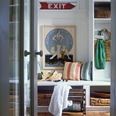 Cloakroom of beach house with storage room and framed poster with swimming motif