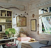 Rustic room with wooden walls, single bed with ornate headboard and bouquet of white hydrangeas