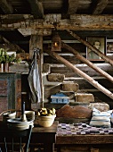 Rustikales Treppenhaus mit alten Deckenbalken, einer antiken Laterne und einer rustikalen Holzsitzbank