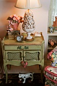 Antique bedside table with ceramic bowl of flowers as lamp base