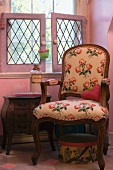 Armchair with rose-patterned upholstery in pink room