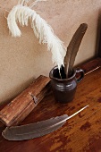 Federn in Tinte und eine antike Holzschatulle für Federn