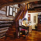 Foyer of farmhouse with elaborately carved chair against staircase