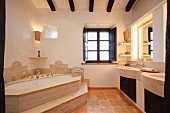 Eckbadewanne mit Stufen und Waschtisch in elegantem Bad eines mediterranen Landhauses