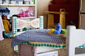 Gedeckter Kindertisch mit zart bemaltem Holzstühlchen und verschwommener Karodecke