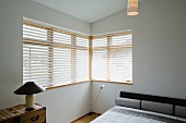 Contemporary bedroom with gray bed and corner windows