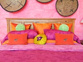 Pink and orange throw pillows on bed