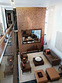 Blick von Galerie auf elegante Wohnzimmereinrichtung mit brauner Polstermöbelgarnitur und raumhoher Trennwand