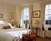 Traditional bedroom with floor-length curtains at latticed windows