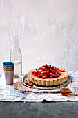A cheesecake with strawberries and ginger syrup