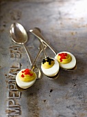 Three Deviled Eggs Topped with Caviar on Vintage Spoons