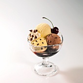 Chocolate and vanilla ice cream sundae with cherry sauce and cherries