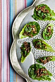 Schweinegeschnetzeltes mit Koriandergrün in Salatblättern