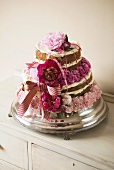 Multi-layer wedding cake decorated with pink flowers and ribbons