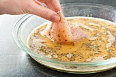 Dipping Chicken in Seasoned Egg; Step in Making Crunchy Baked Chicken
