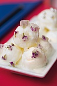 Mini scoops of vanilla ice cream with iced viola flowers for the sweet fondue