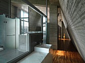 Designerbad im offenen Dachgeschoss mit Sichtbetonwand