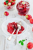 Erdbeermarmelade auf einem Teller und frische Erdbeeren