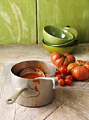 Saucepan of tomato soup on table
